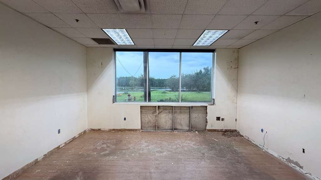 Same office before renovation, with damaged walls and flooring