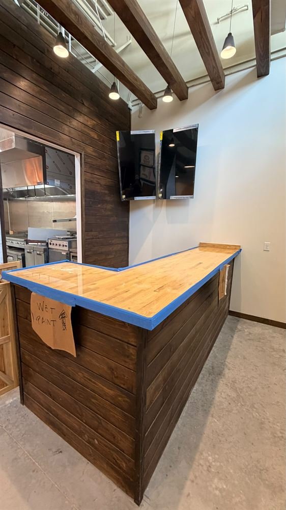 Custom cafe service counter with wood slat wall and exposed beams