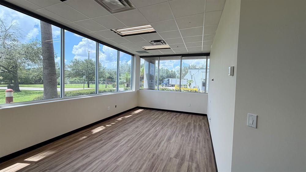 Finished corner office with floor-to-ceiling windows and new vinyl plank flooring