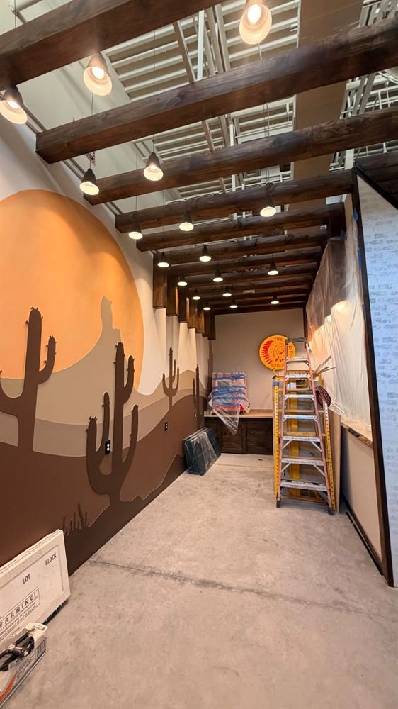 Retail space with painted desert mural and industrial ceiling